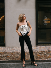 a lady wearing a polka dots printed silk scarf as a top with black jeans
